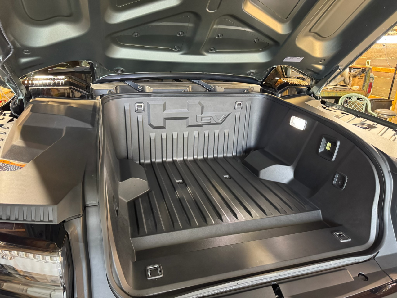 Hummer in a garage that has been detailed and is showing the trunk open. |Mystic AC Detailing