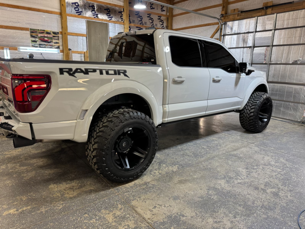 White Ford  Raptor after full body detailing service with black lift tires and custom rims | Mystic AC Detailing