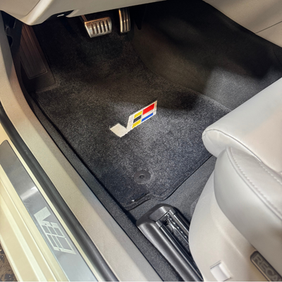 Cleaned floor boards and floor mats of a white cadillac that received a full service auto detail