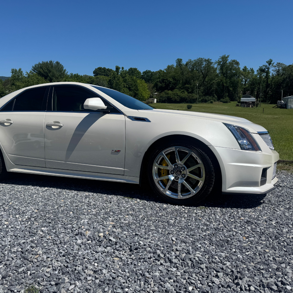 white cadillac sitting outside in the sun after a full service detail